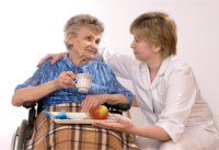 A caregiver assists her patient in having a meal