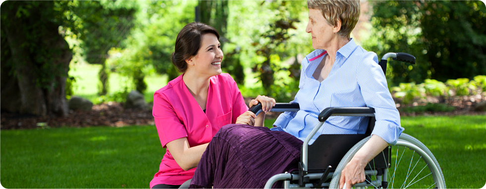 A patient on a wheelchair with her caregiver